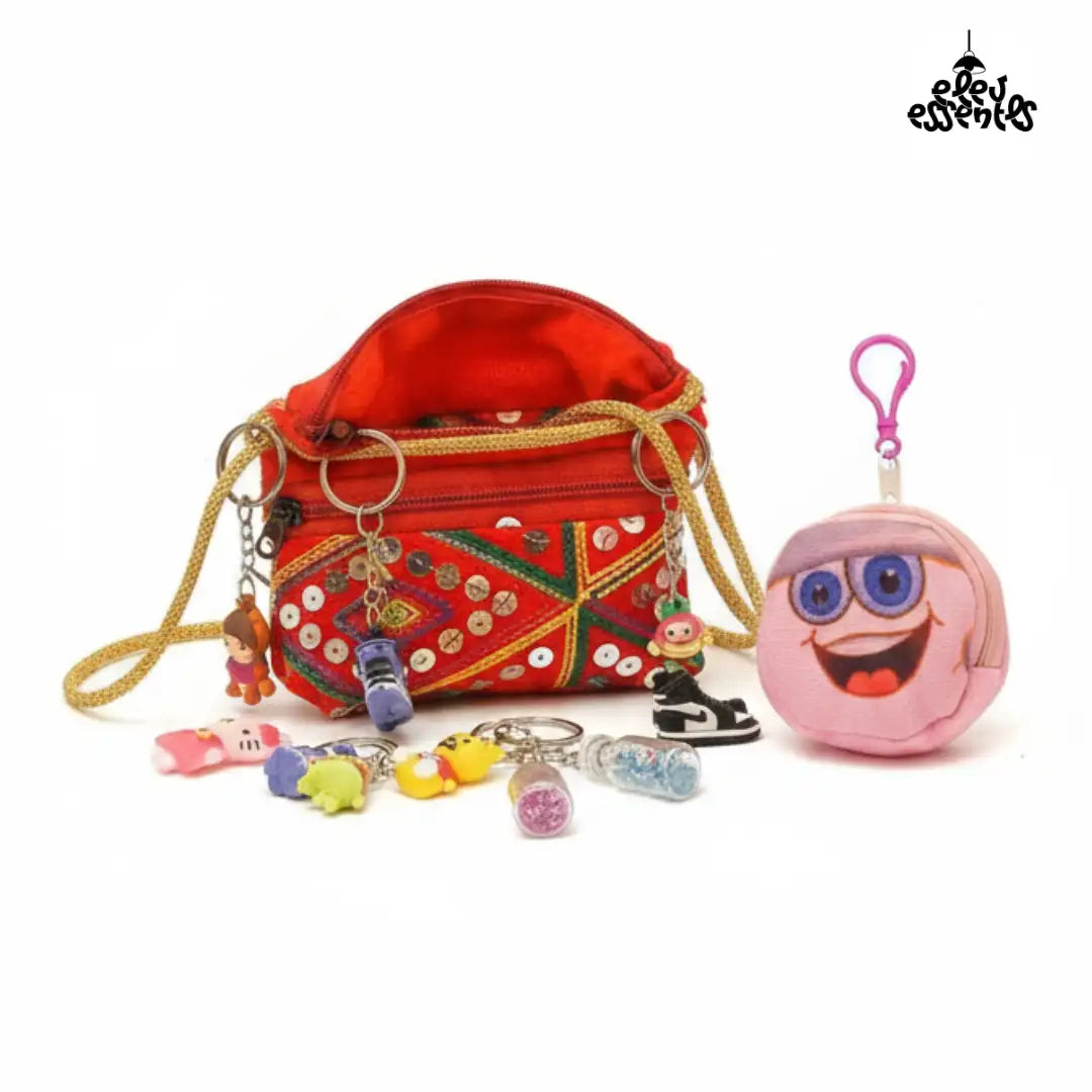 Navratri Hamper with Gujrati red bag with keychain and charm set, and a pink character pouch on a white background.
