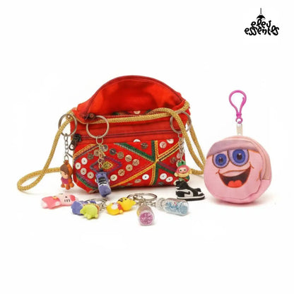 Navratri Hamper with Gujrati red bag with keychain and charm set, and a pink character pouch on a white background.